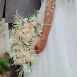 A bride holding an aesthetic flowery fan in her hand