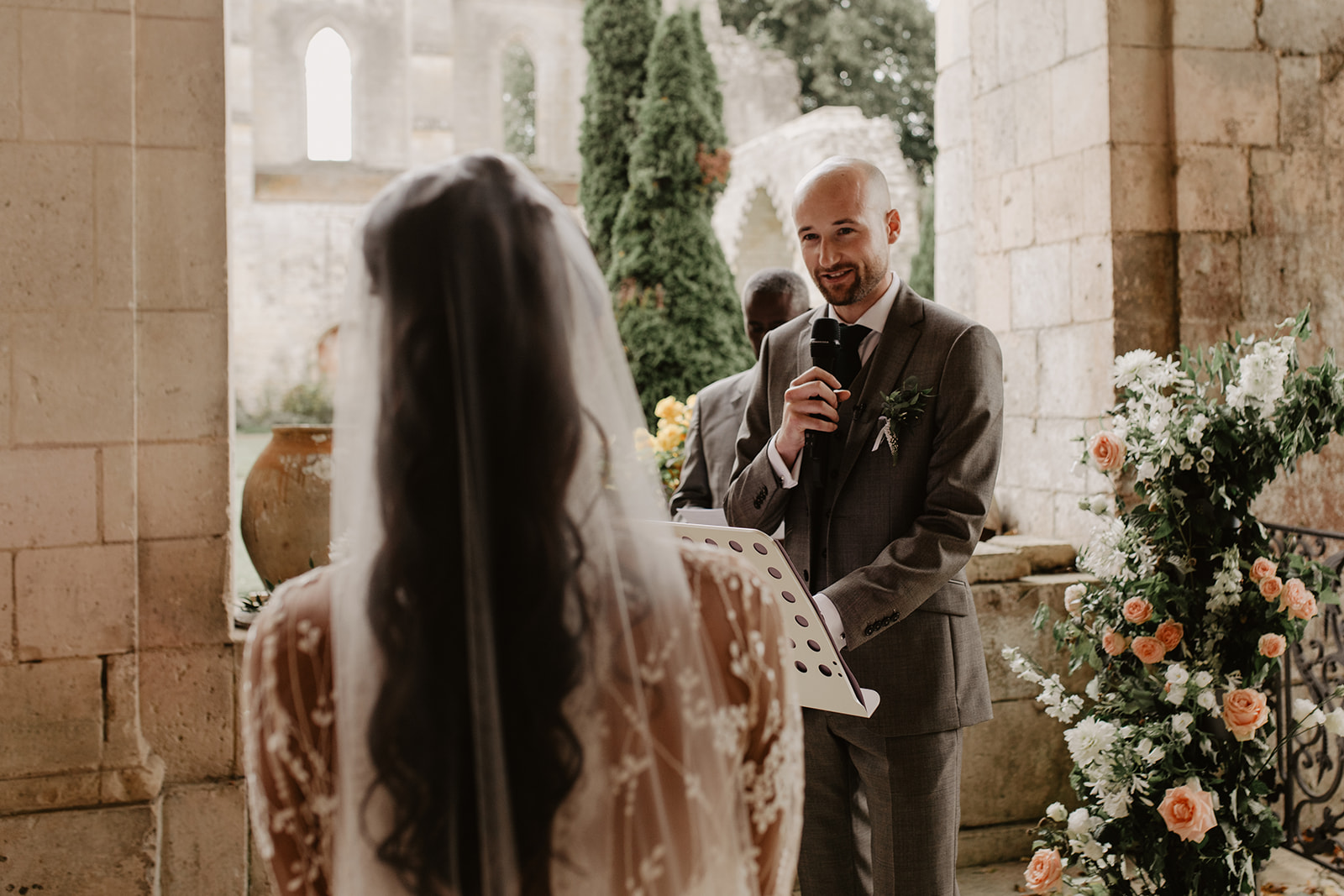 Groom and brides saying their vows in a secular ceremony outdoor.