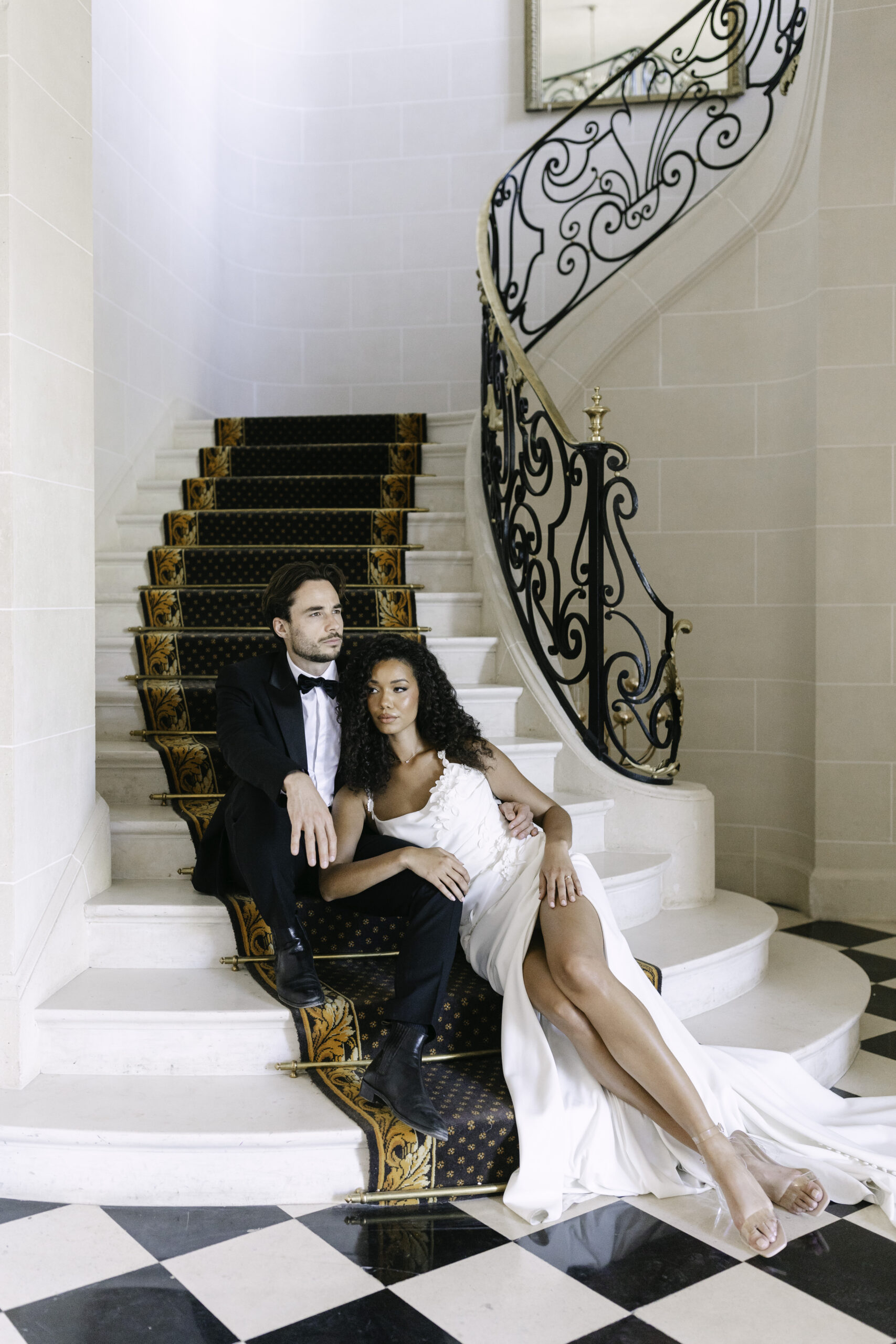 Bride and groom sitting in the beautiful white and gold stairs