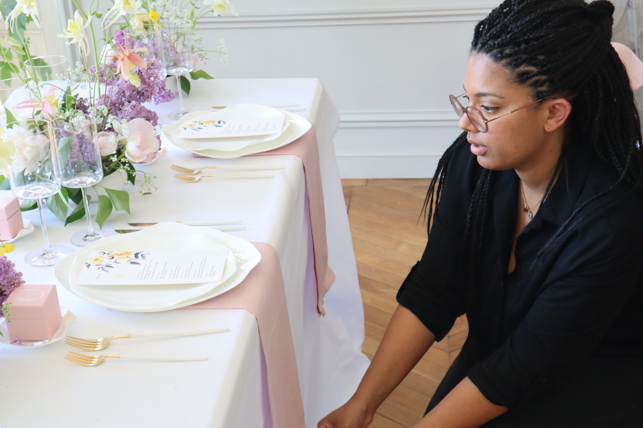 Wedding planner Marie-Svetlana Kadjo carefully adjusting the alignment of elegant table decor during a luxury wedding setup in Paris.